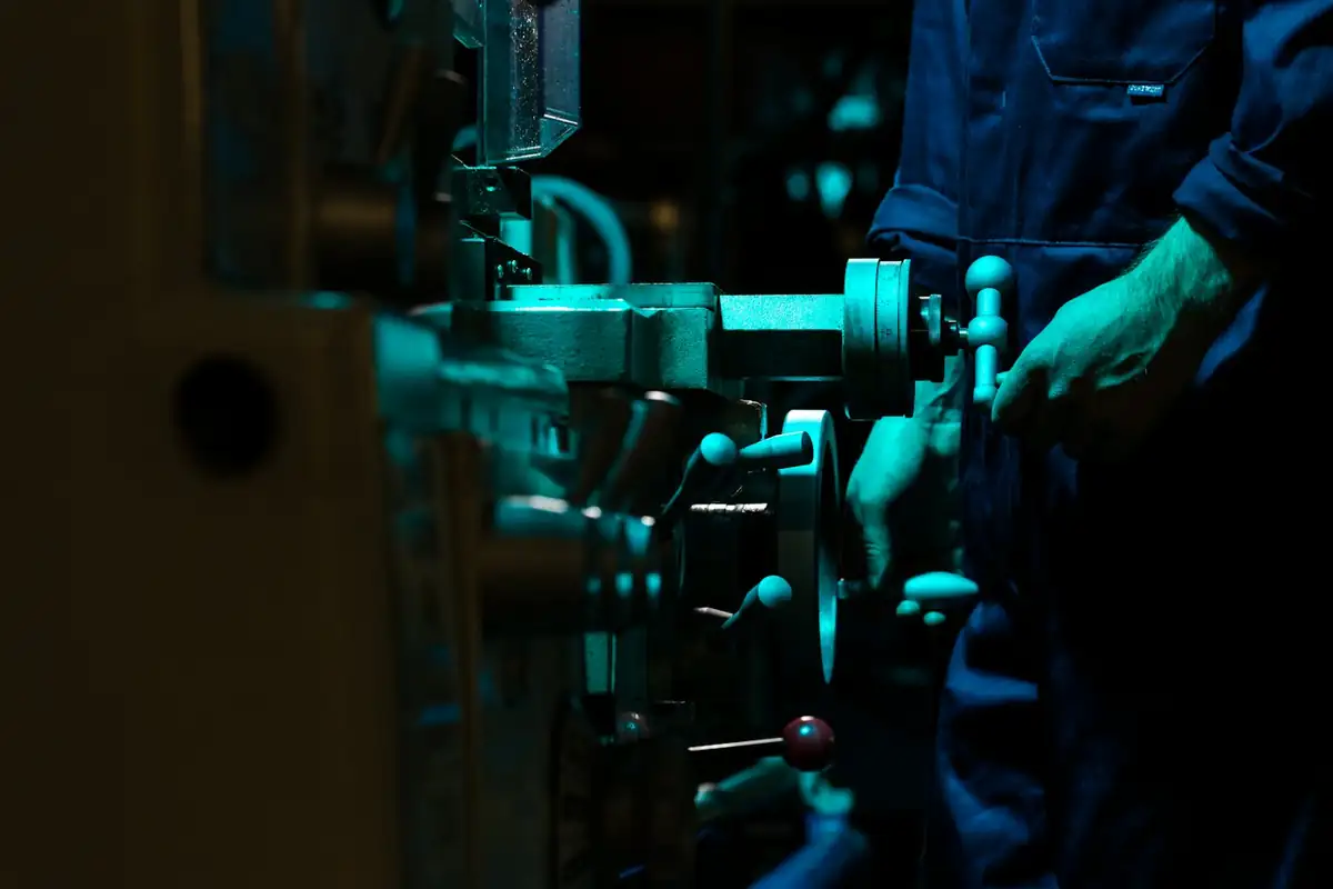 Técnico ajustando comandos de uma máquina industrial (foto ilustrativa)